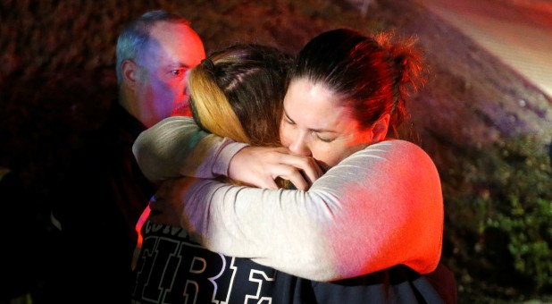 People comfort each other after a mass shooting at a bar in Thousand Oaks, California.