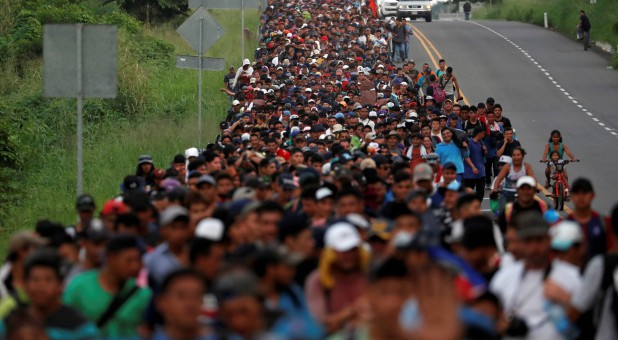 Migrants, part of a caravan traveling from Central America en route to the United States, walk by the road that links Ciudad Hidalgo with Tapachula, Mexico.