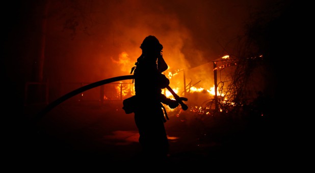 A firefighter battles the Woolsey Fire in Malibu, California.