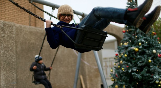 Iraqi Christians play outside St George Chaldean Catholic Church after a Mass on Christmas in Baghdad, Iraq.