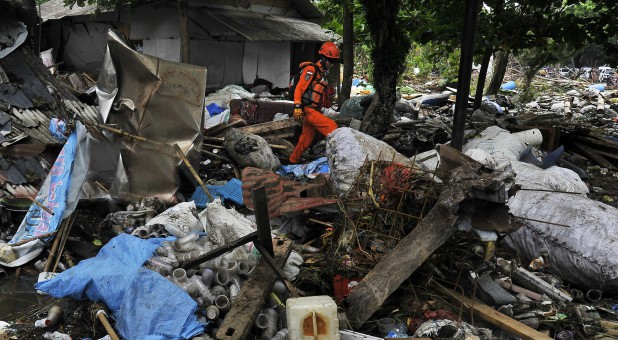 Rescue worker walks as he searches for victims among debris after a tsunami hit Sunda Strait at Carita district in Pandeglang, Indonesia, Dec. 25, 2018.