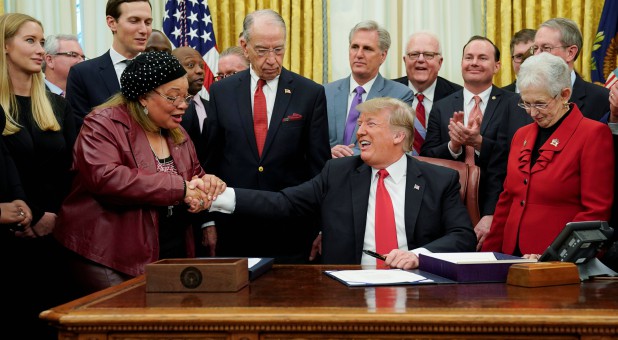 U.S. President Donald Trump shakes hands with Alveda King.