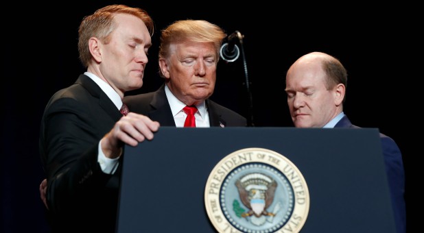 U.S. President Donald Trump joins Senators James Lankford, R-Okla., and Chris Coons, D-Del., in prayer at the National Prayer Breakfast.