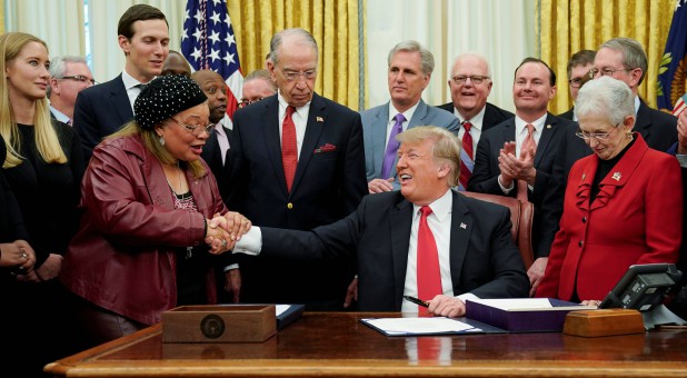 U.S. President Donald Trump shakes hands with Alveda King.