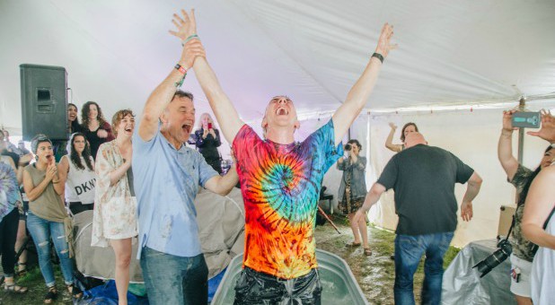 A man praises the Lord after his baptism at Bonnaroo.