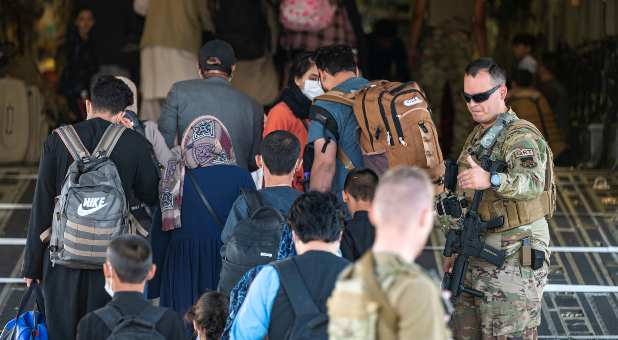 U.S. Air Force Airmen guide qualified evacuees aboard a U.S. Air Force C-17 Globemaster III at Hamid Karzai International Airport (HKIA), Afghanistan, August 24, 2021.