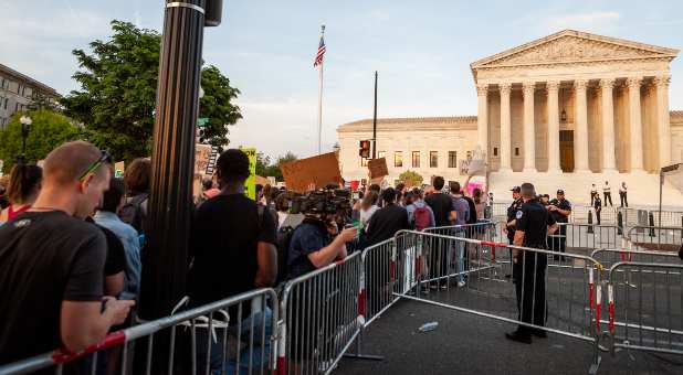 Capitol Police officers stand behind a barricade during a pro-choice rally at the Supreme Court the day after learning that Court justices voted to overturn Roe v. Wade in a draft opinion for the Dobbs v. JWHO case. Police had set up the barricades to separate pro-choice and pro-life protesters; however, several thousand pro-choice and roughly 25 pro-life demonstrators were present.