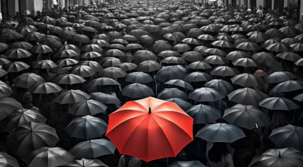 Red umbrella stands out from among the crowd.