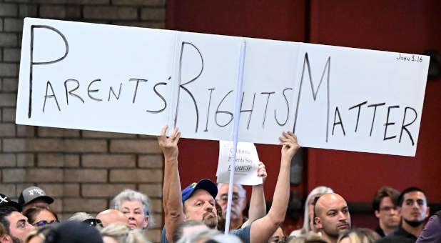 Parent holding a sign in protest.