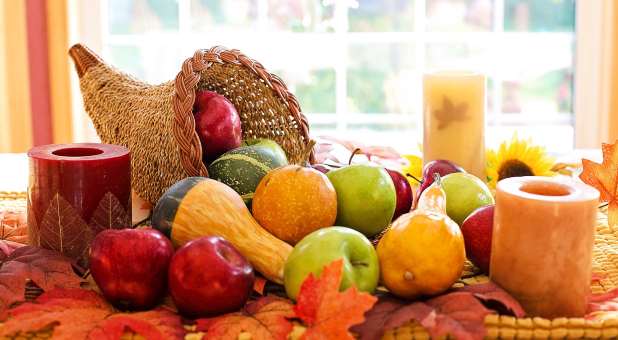 Thanksgiving cornucopia with vegetables, fruits and candles