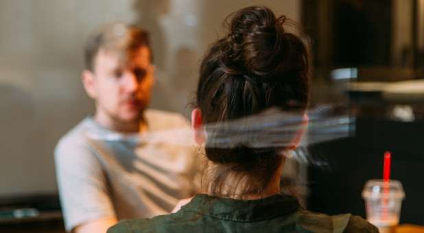 Man talking to woman in coffee shop.