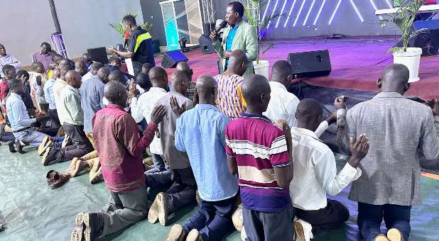 Men confessing and praying at the altar in Rwentobo, Uganda.