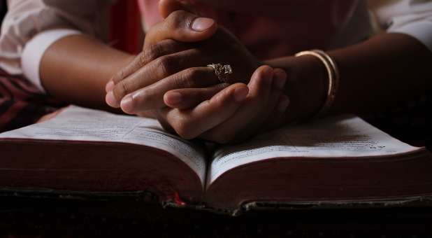 praying hands on Bible