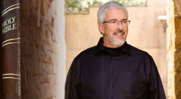 Perry Stone standing next to enlarged image of the Bible.