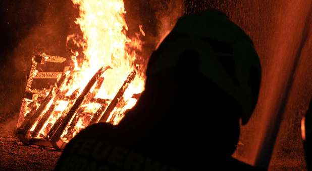 shadowed figure with flames in background