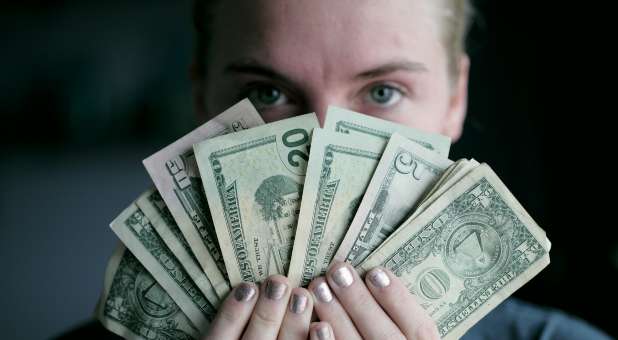 Woman fanning series of bills in various denominations.